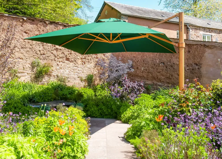 green cantilever parasol with a wood effect frame in lush garden