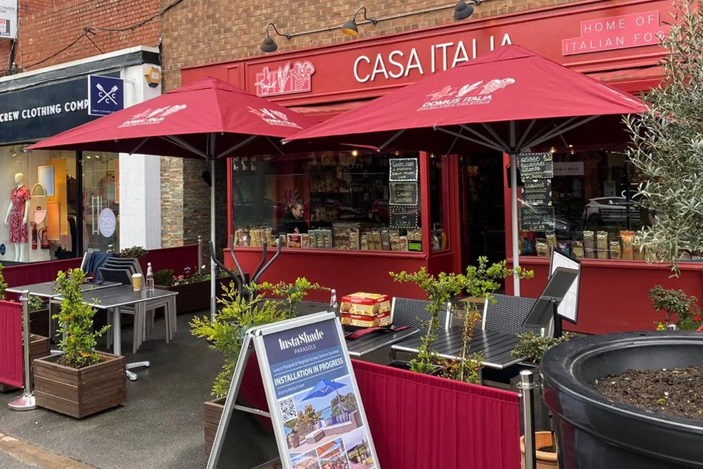 Vibrant red custom branded Instashade cafe series parasols installed outside Casa Italia in Wilmslow.