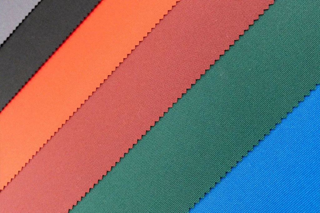 Close up of premium marine grade solution dyed luxury parasol canopy fabric swatch samples showcasing a range of vibrant weatherproof colours.