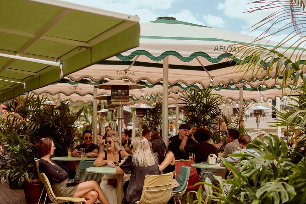 Commercial scalloped valance Nova parasols providing cohesive alfresco seating shade at Afloat venue.