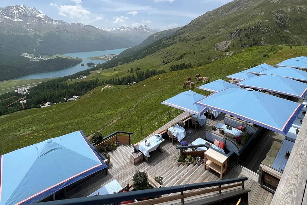 Blue luxury commercial parasols with contrast edges overlooking the lake and alpine slopes at Paradiso St. Moritz.